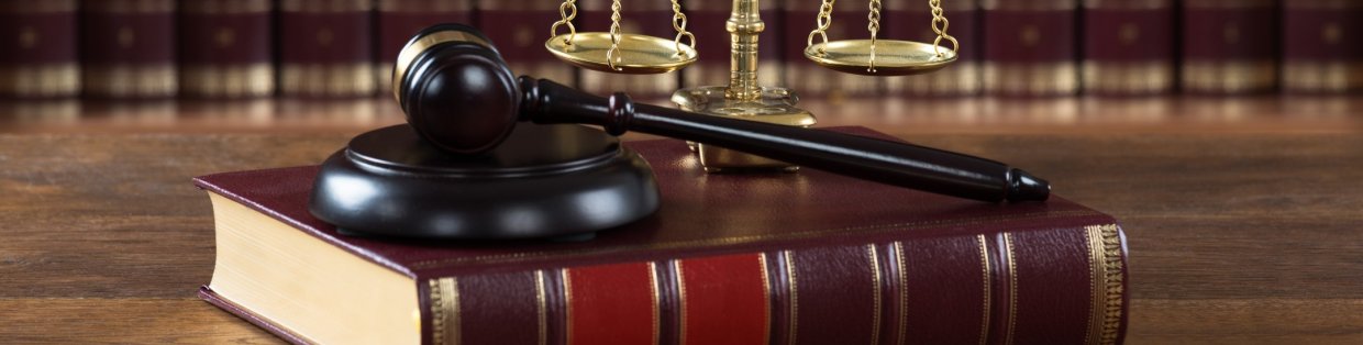 A close up image of a gavel, book, and justice weights. 