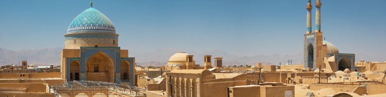 Cityscape of buildings built out of sand with a domed building encased in blue turquoise. 