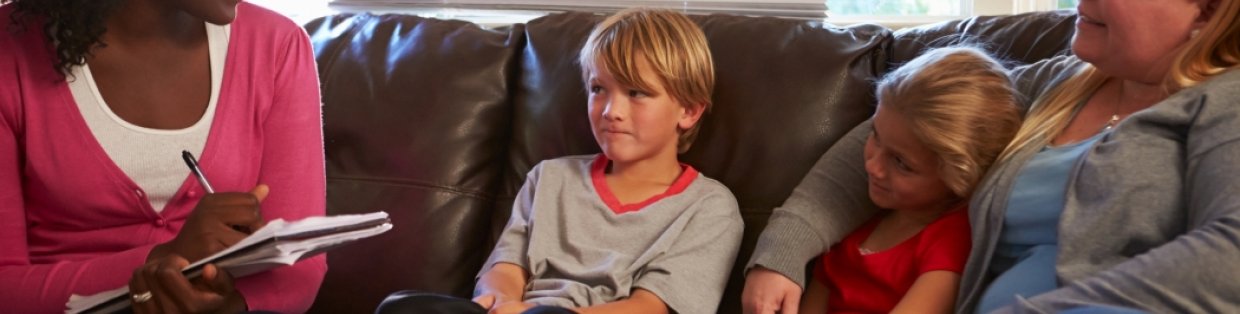 A group of people sitting on a couch talking.