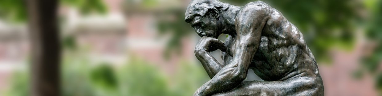 bronze sculpture sitting with hands on chin, contemplating. 
