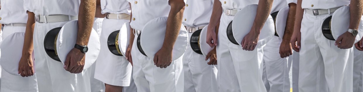 Sailor standing in a line in their dress whites. 