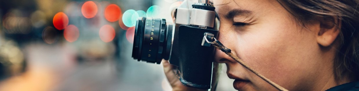 A person looking through a camera lens while taking a photo.