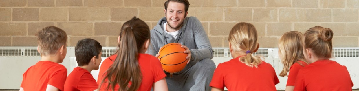 Basketball coach speaking to children.