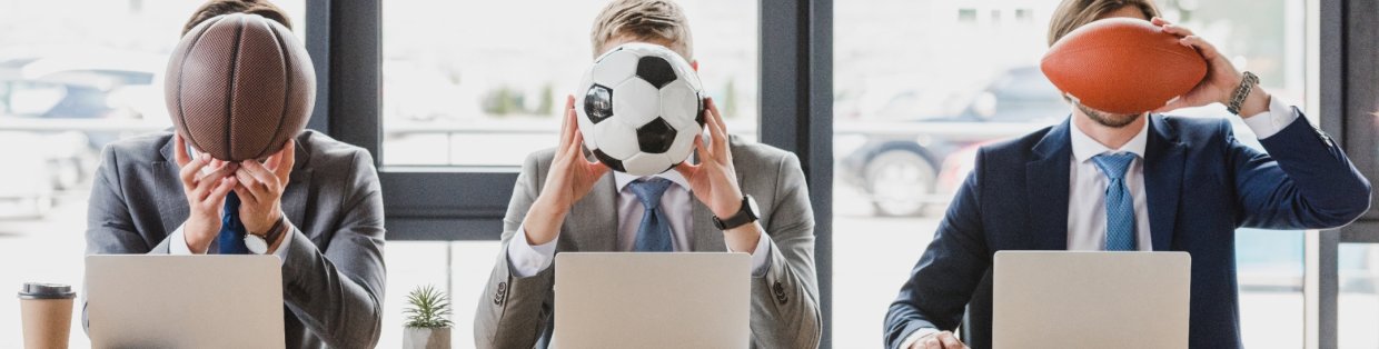 Business professionals placing a sports ball in front of their faces. 