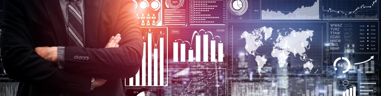 Business man standing in front of a data board with their arms crossed.