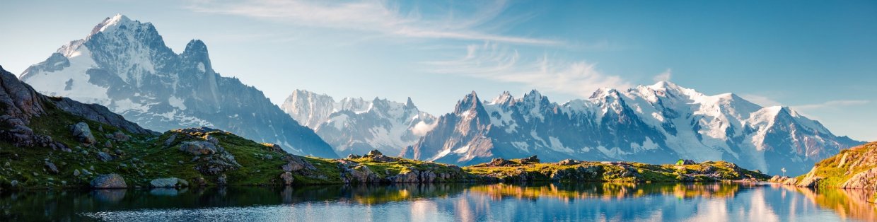 a crisp lake beneath a mountain range on a sunny day