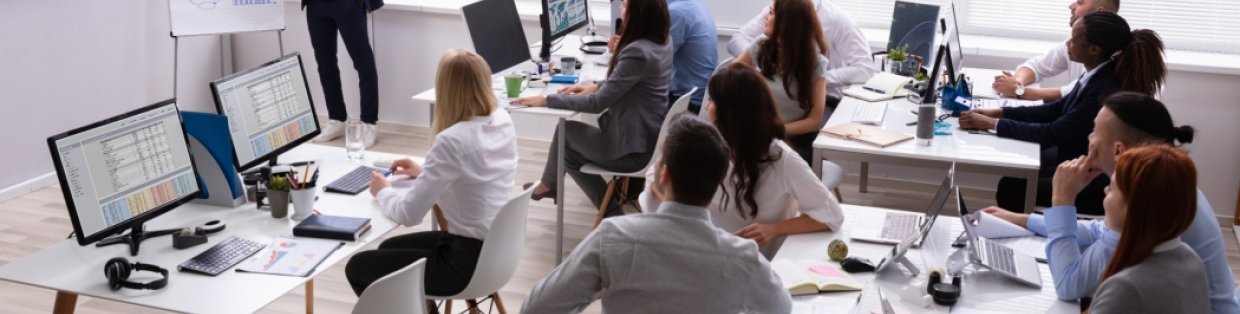 a group of people in a classroom setting watching a lecture. 