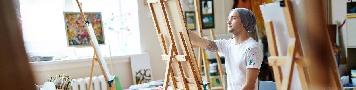 A painter in front of an easel. 