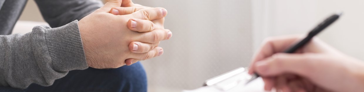 Therapist writing notes during counseling session with singl