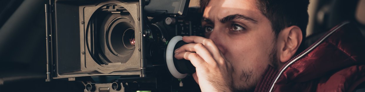 Student looks through film camera. 