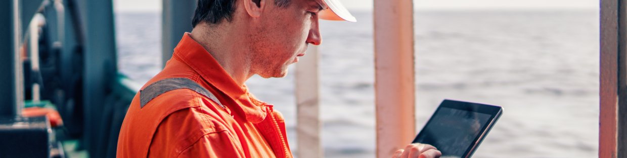 A construction worker looking at an ipad.