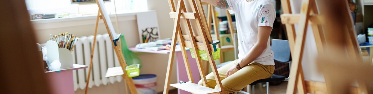 A painter looking at an empty easel. 
