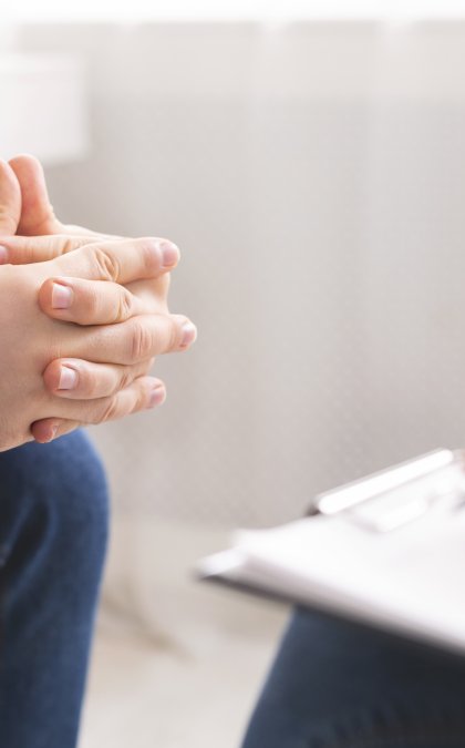 Therapist writing notes during counseling session with singl