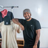 Diego Alonso Cruz Diaz standing next to sport clothing that he designed