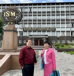Jim Blando, Ph.D., and Anara Shakhmatova, Ph.D., stand in front of a building