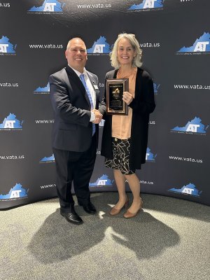 Man and woman standing together with an award plaque