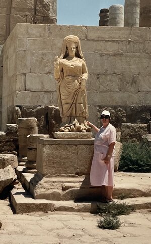 Fran Hassencahl, Ph.D. poses with an ancient statue while visiting Mesopotamia in present-day Iraq.