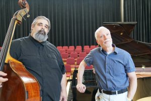 Two men pose with bass violin