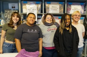 Four students standing with teacher in a group photo