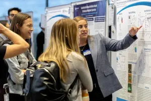 person presenting a poster to an audience