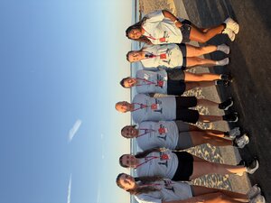 students and faculty standing on beach