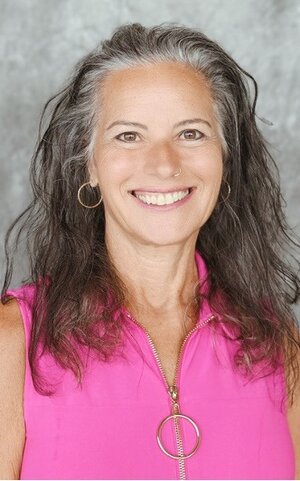 Sylvia Nassar, wearing a pink shirt with her hair down