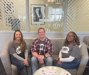Three staff members from the transfer center sit on a couch