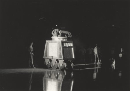 A mechanical Big Blue Beast rolls onto a basketball court. 