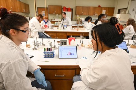 Biology students sit at lab tables in classroom