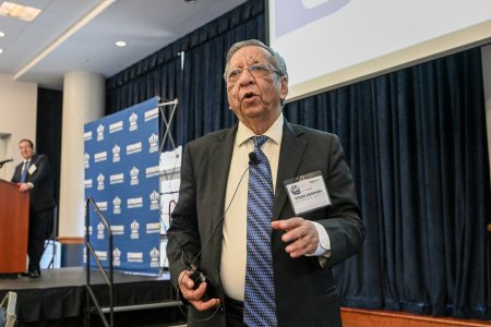 A man talks to a crowd of people.