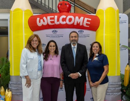 Dr. Abuhamad and three nurses stand under Ellmer welcome sign at event