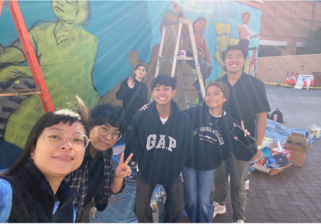 Filipino American students in front of mural