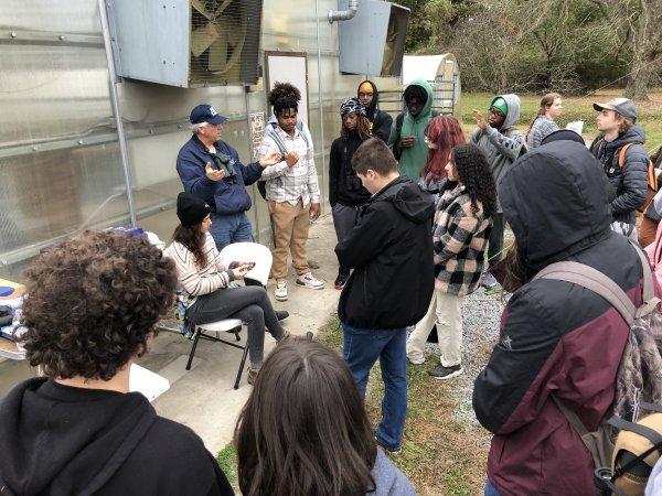 a group of people look at a woman holding a small bird