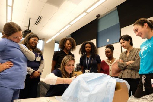 Med student demonstrates how to deliver a baby