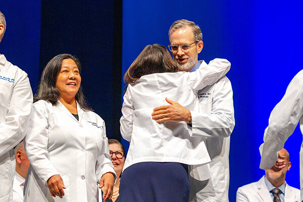 Celia hugging dad at White Coat Ceremony