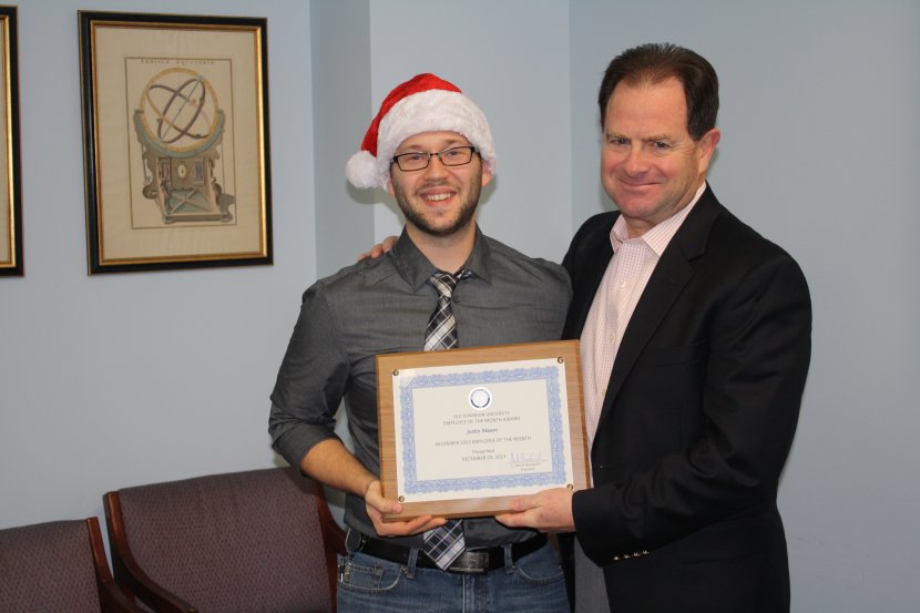 December, 2013, Employee of the Month Justin Mason receives a commemorative plaque from ODU President John R. Broderick