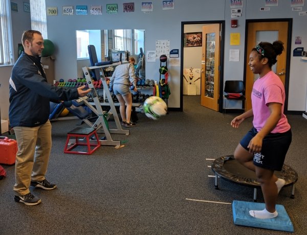 Photo of Athletic trainer Bradley Jackson working with Sha’Q