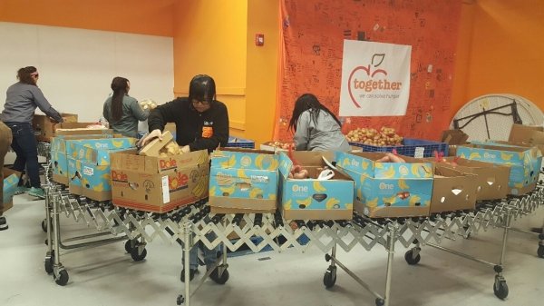 Photo of volunteers packing boxes with fresh produce, meat, 