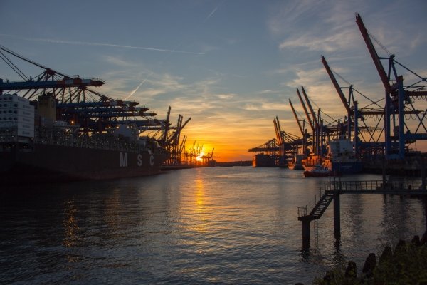 Cargo ships and cranes at sunset