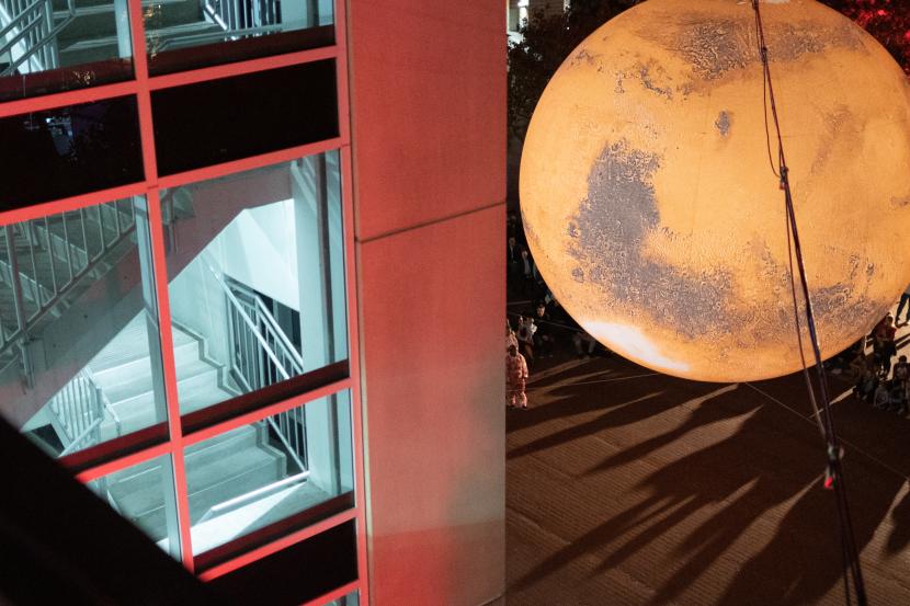 Red lights reflecting off the parking garage enhance Mars. P