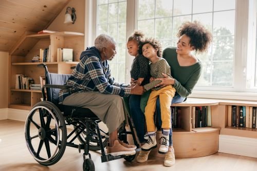 Black woman in wheelchair talks with daughter and grandchild