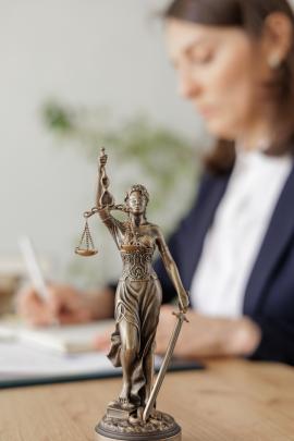 Blind justice statue with paralegal