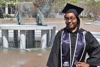  Destini Harrell, stands at the ODU lion fountain as an ODU graduate, years before joining the University as a faculty member. 