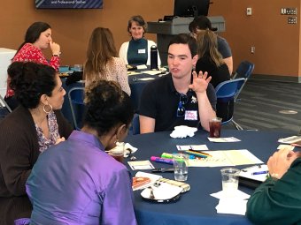 Participants and guests socialize before the panel discussio