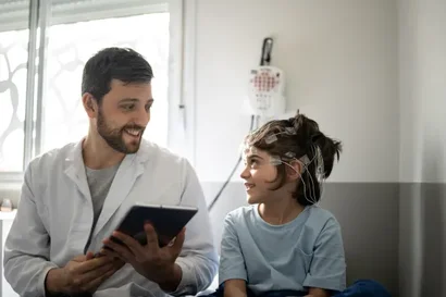 Neurologist with child hooked up to electrodes