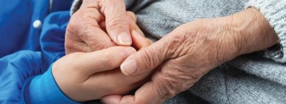 Closeup of young and old hands clasping