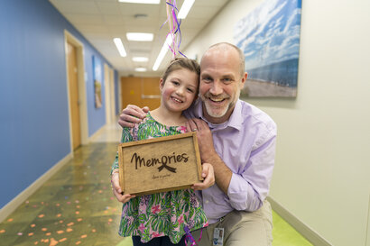 doctor and child stand with a sign