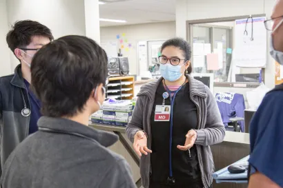 A female doctor explaining something to 3 other health care 