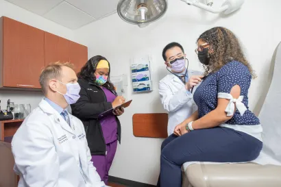 Three EVMS providers talking with a patient while one of the