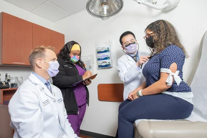 Three EVMS providers talking with a patient while one of the